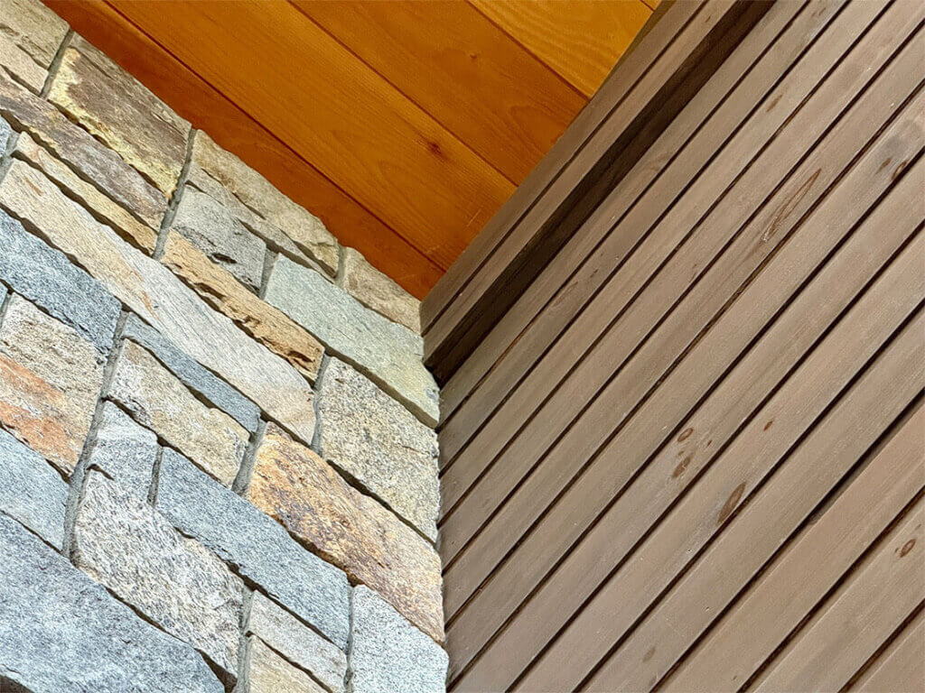 Stone and wood siding angle, highlighting texture and color contrast.