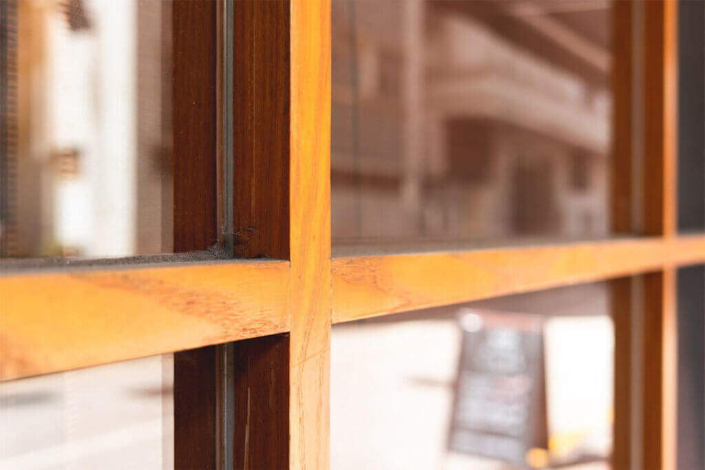 Wood-framed commercial window with reflections, suitable for repair services.